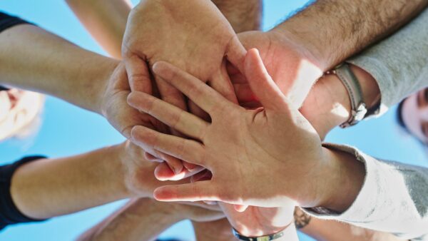 Kuvassa monen eri ihmisen kädet päällekkäin laitettuna