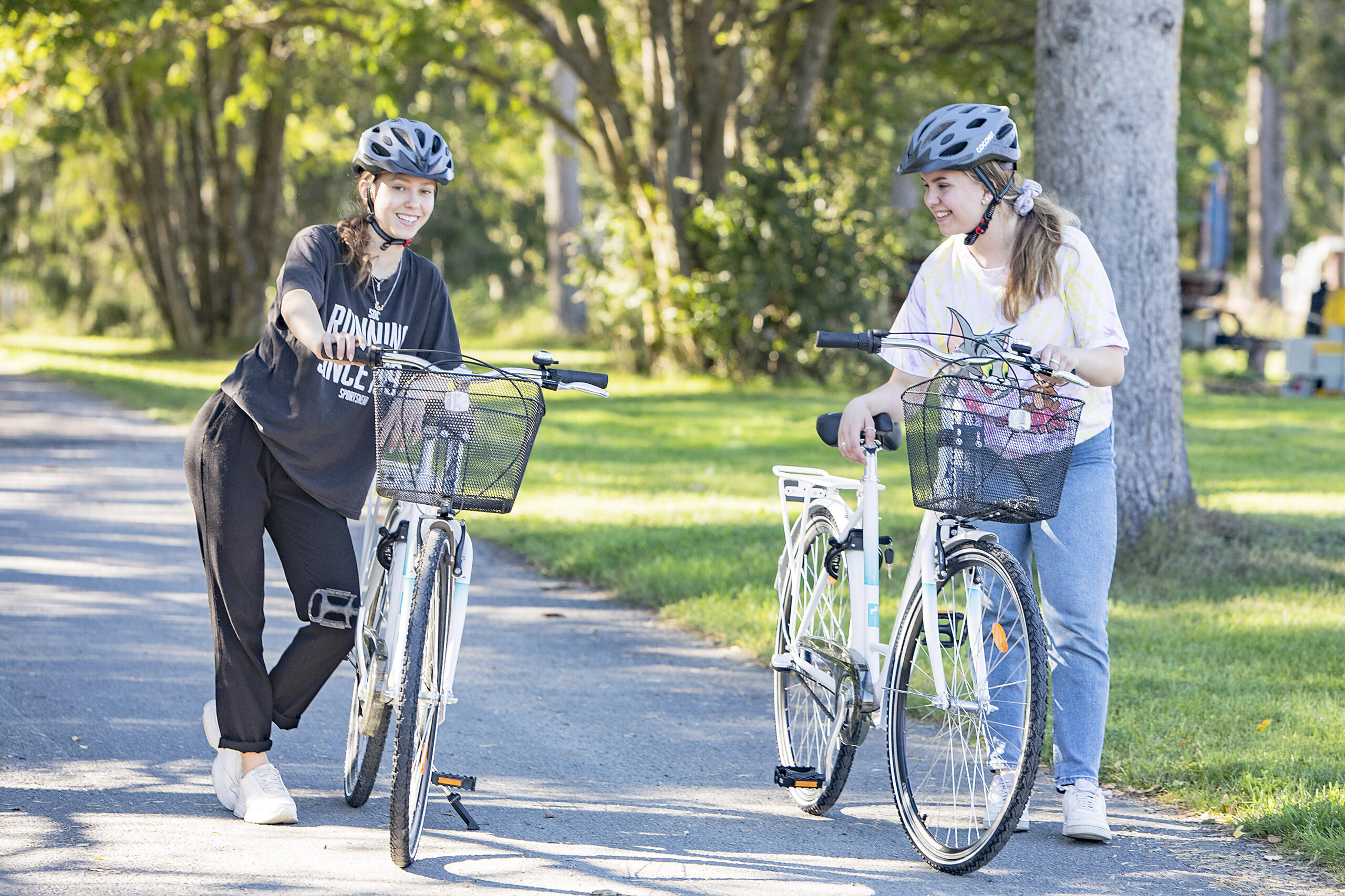 Kaksi opiskelijatyttöä lähdössä pyöräilemään.