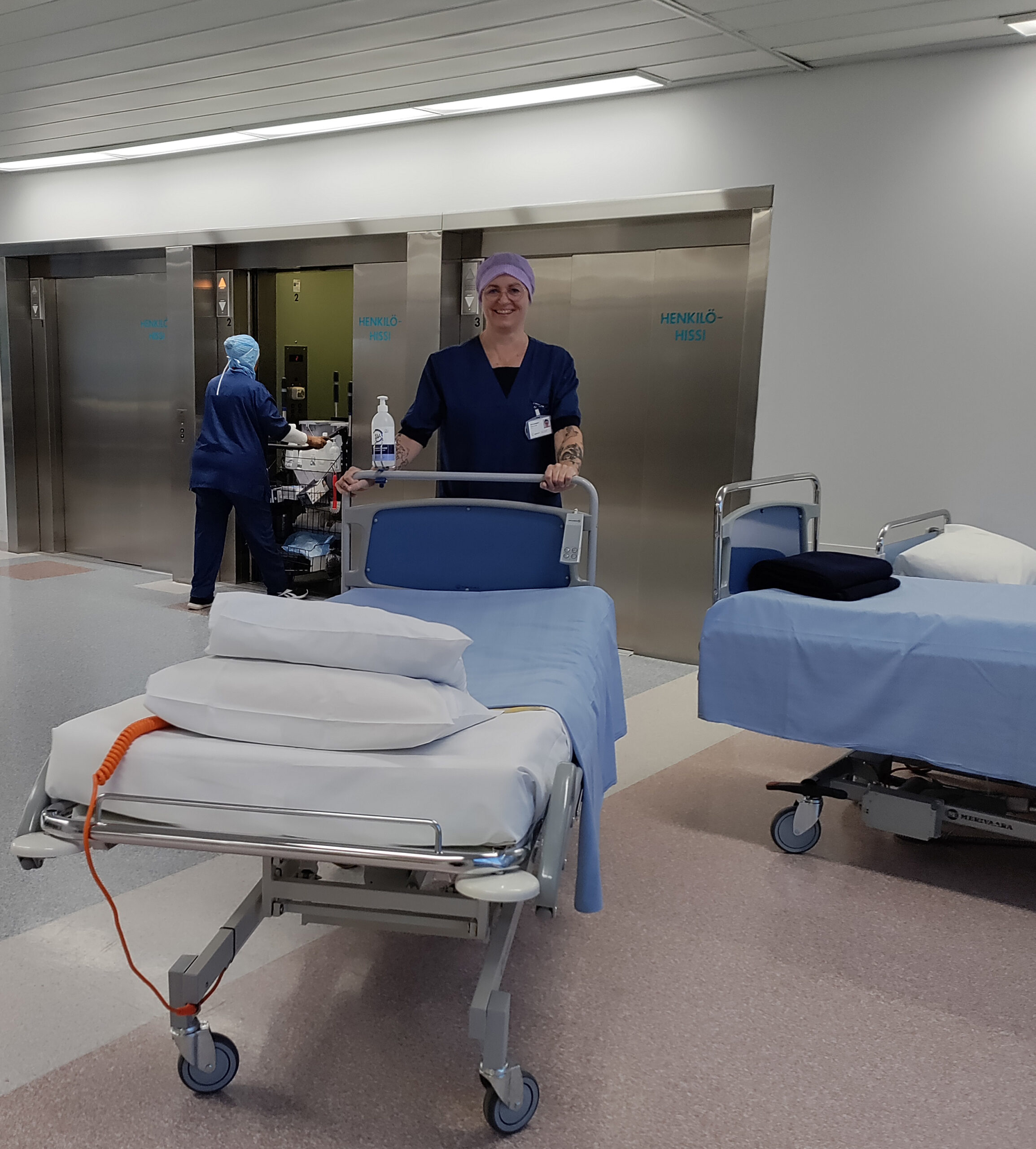 Laitoshuoltaja Terhi Rantajärvi vie potilassänkyä osastolle.