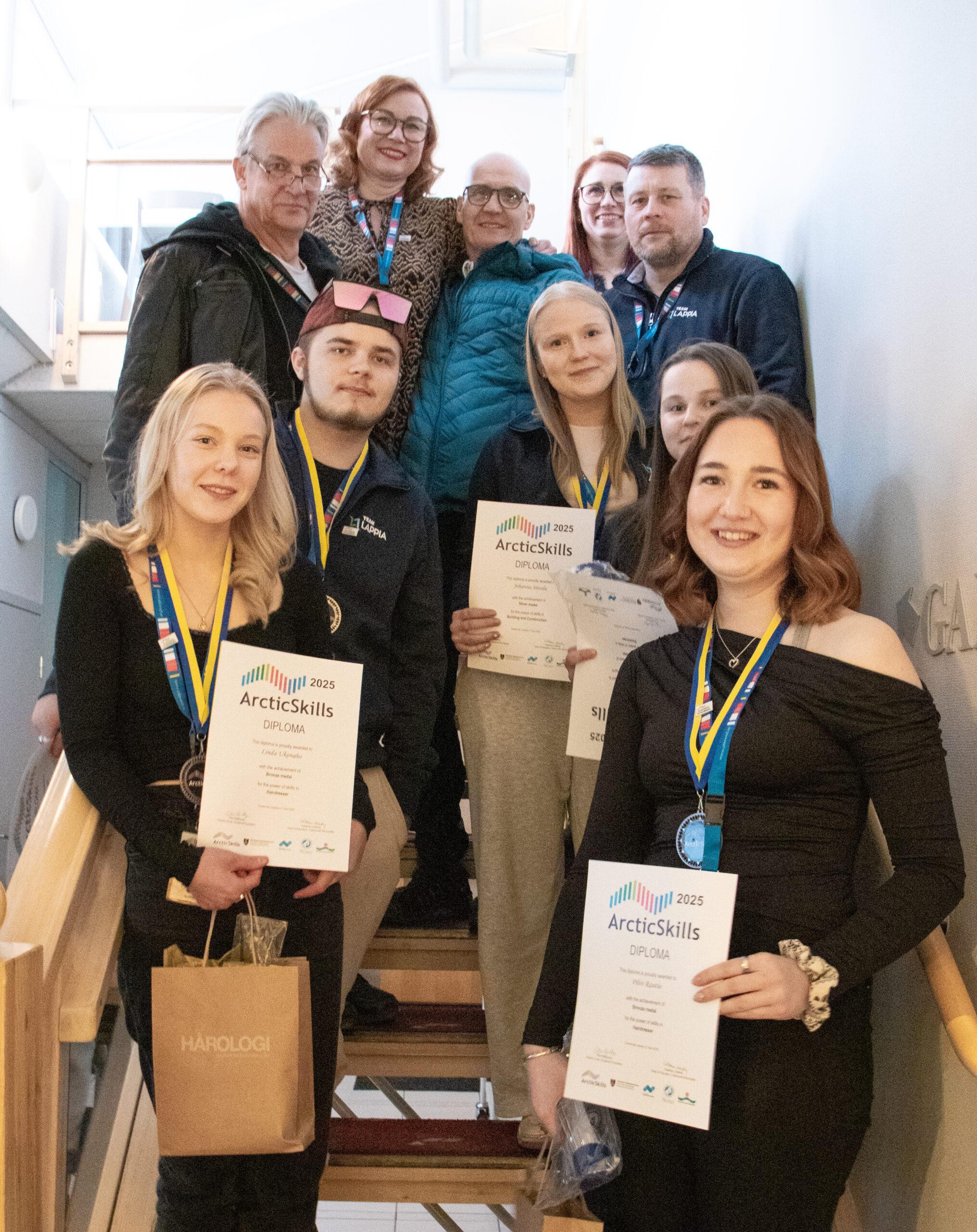 Lappian mitalistit ja valmentaja-opettajat. Ylärivi vasemmalta: sähkö- ja automaatioalan opettaja Mikko Rokkonen, hiusalan opettaja Leena Leskio, rakennusalan opettaja Veijo Matala, ajoneuvoalan opettaja Denice Hohtari sekä Lappian kilpailutoiminnasta vastaava koulutuspäällikkö Jani Harju. Alarivi vasemmalta: hiusalan kilpailija Linda Ukonaho, ajoneuvoalan kilpailija Topi Kivilompolo, rakennusalan kilpailija Johanna Siivola, sähköalan kilpailija Ida-Maria Kokkinen sekä hiusalan kilpailija Pilvi Rautio.