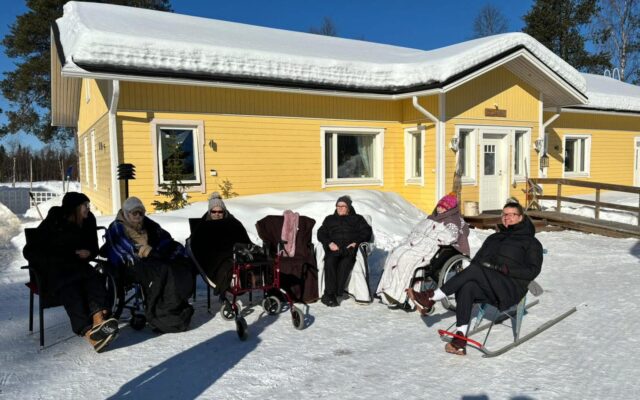 Ikääntyneitä yhteisöasumiskodin pihalla.