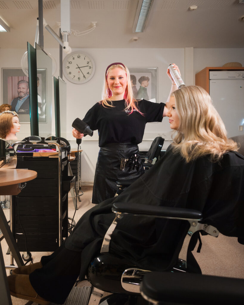 Hiusalan opiskelijat hiuspysäkillä työpisteellä