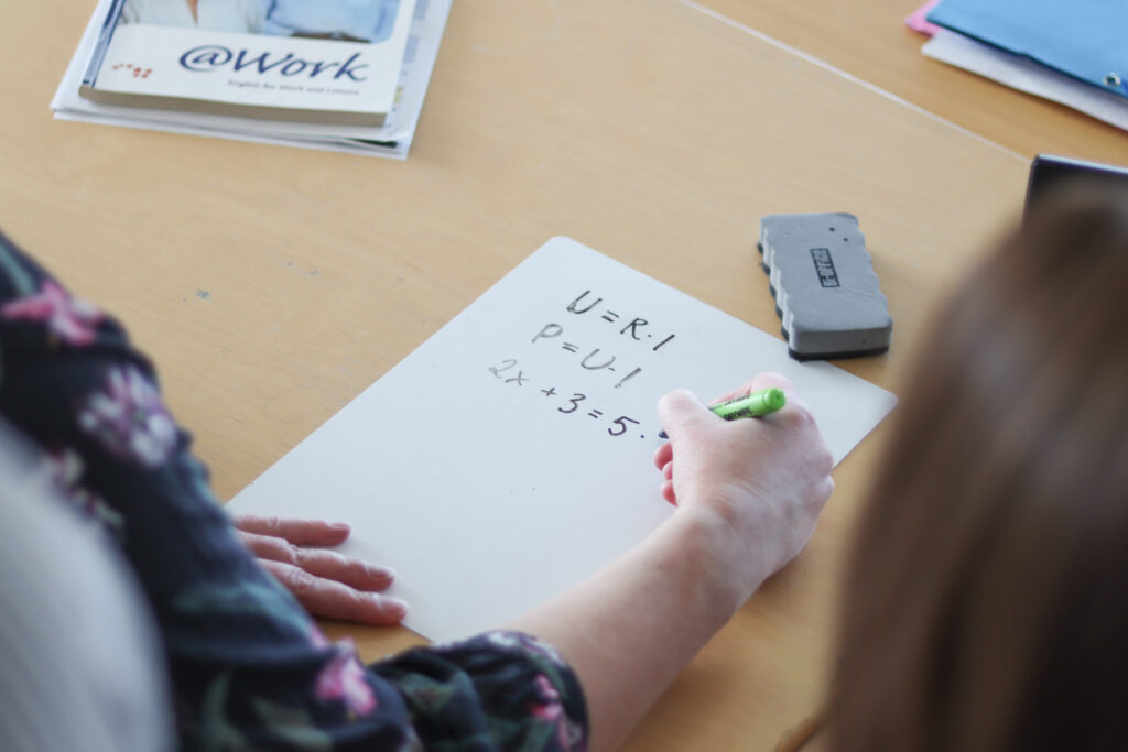 Opettaja piirtää laskukaavoja.