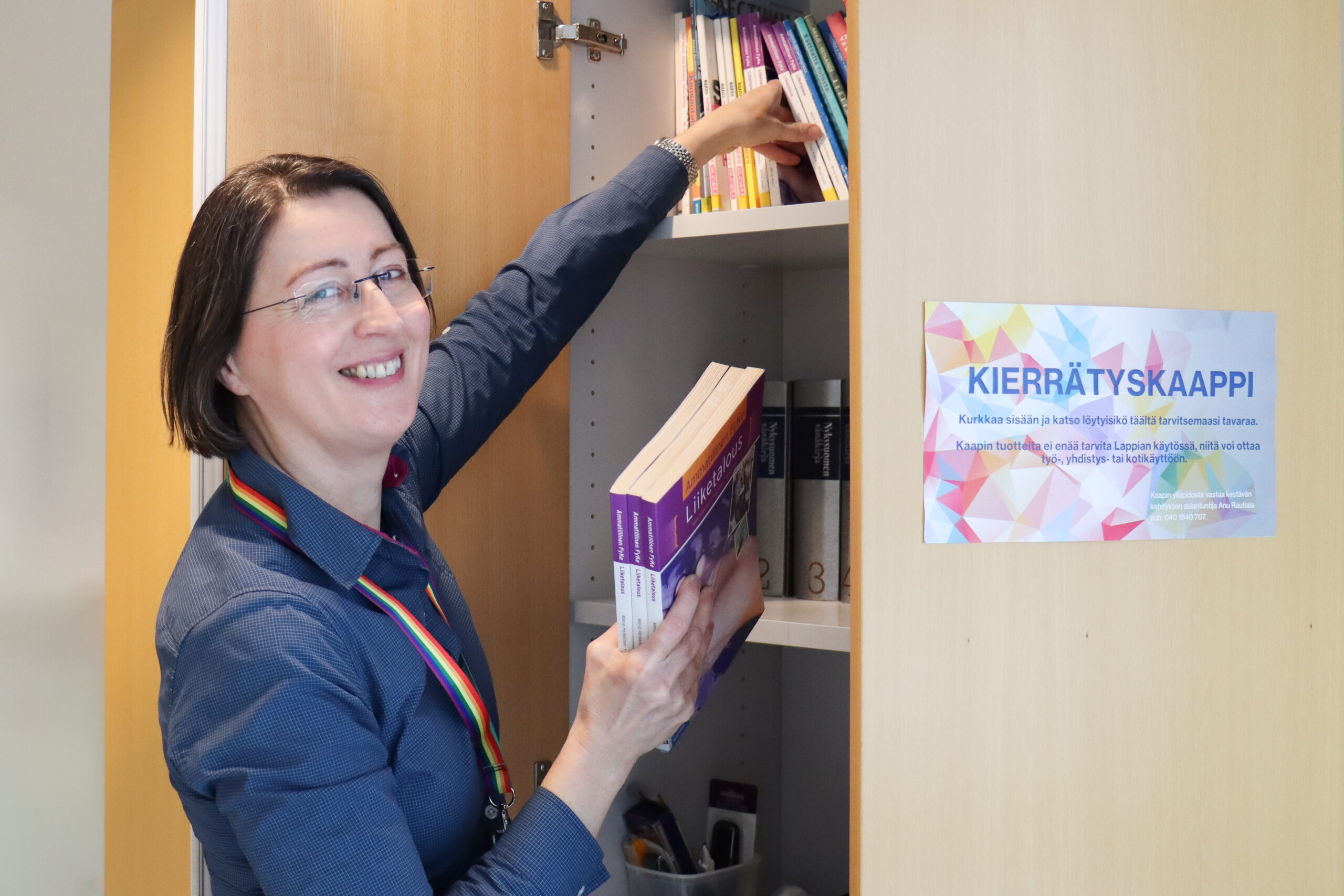 Kestävän kehityksen asiantuntija Anu Rautiala järjestelee kierrätyskaappiin kirjoja.