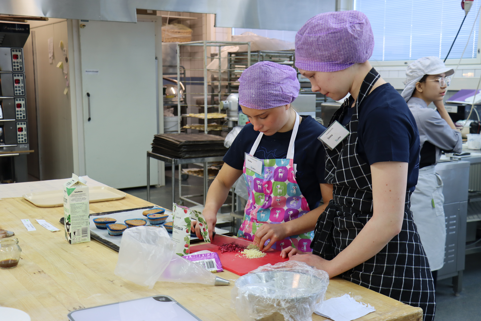Kahdeksasluokkalaiset Minka ja Emma Osaajakisojen leipuri-lajin tehtävän parissa.